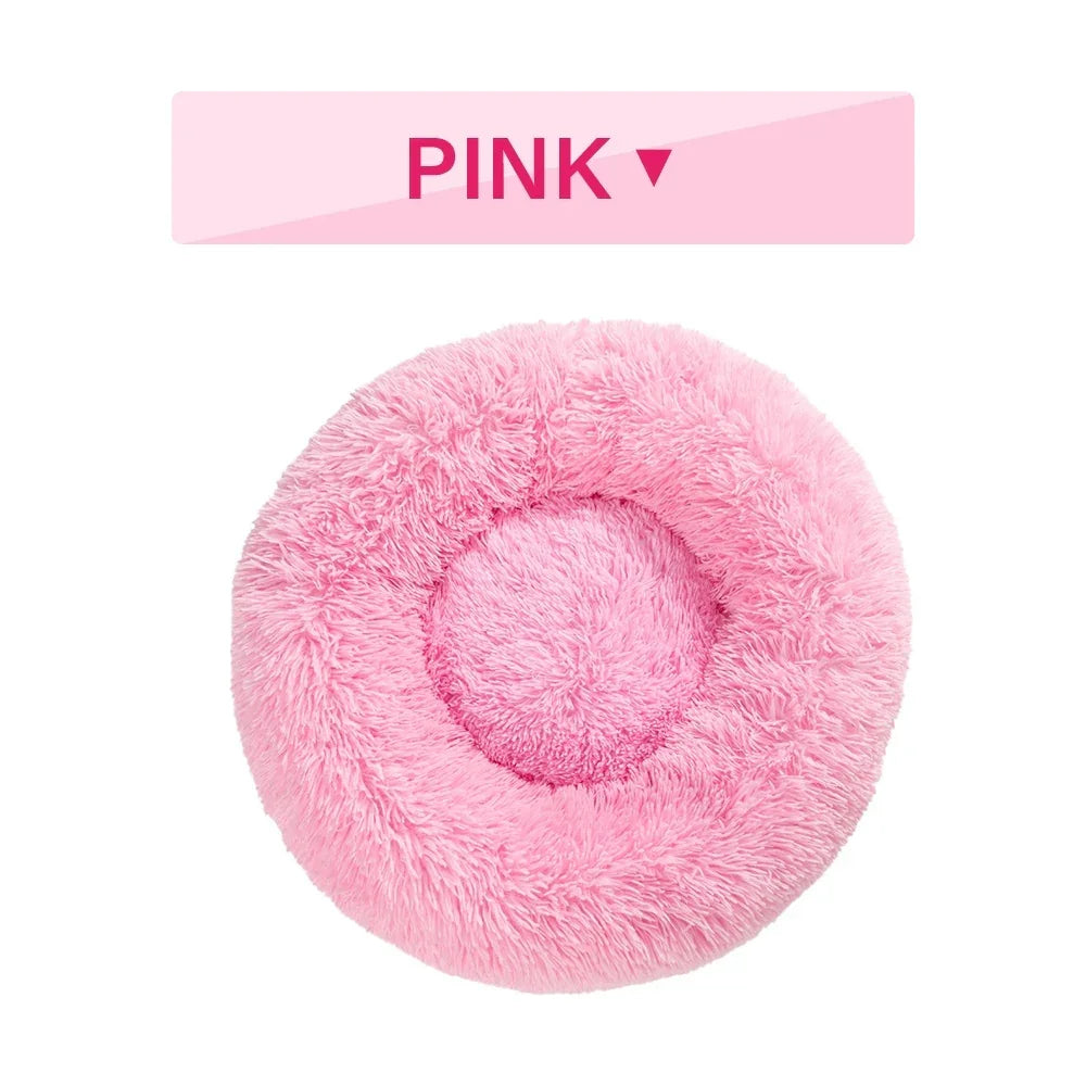 Pink fluffy round pet bed with raised rim on white background