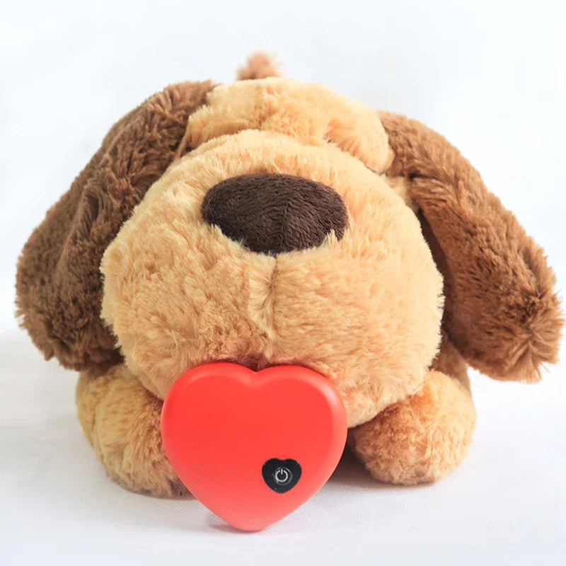 Plush brown stuffed dog toy holding a red heart-shaped device