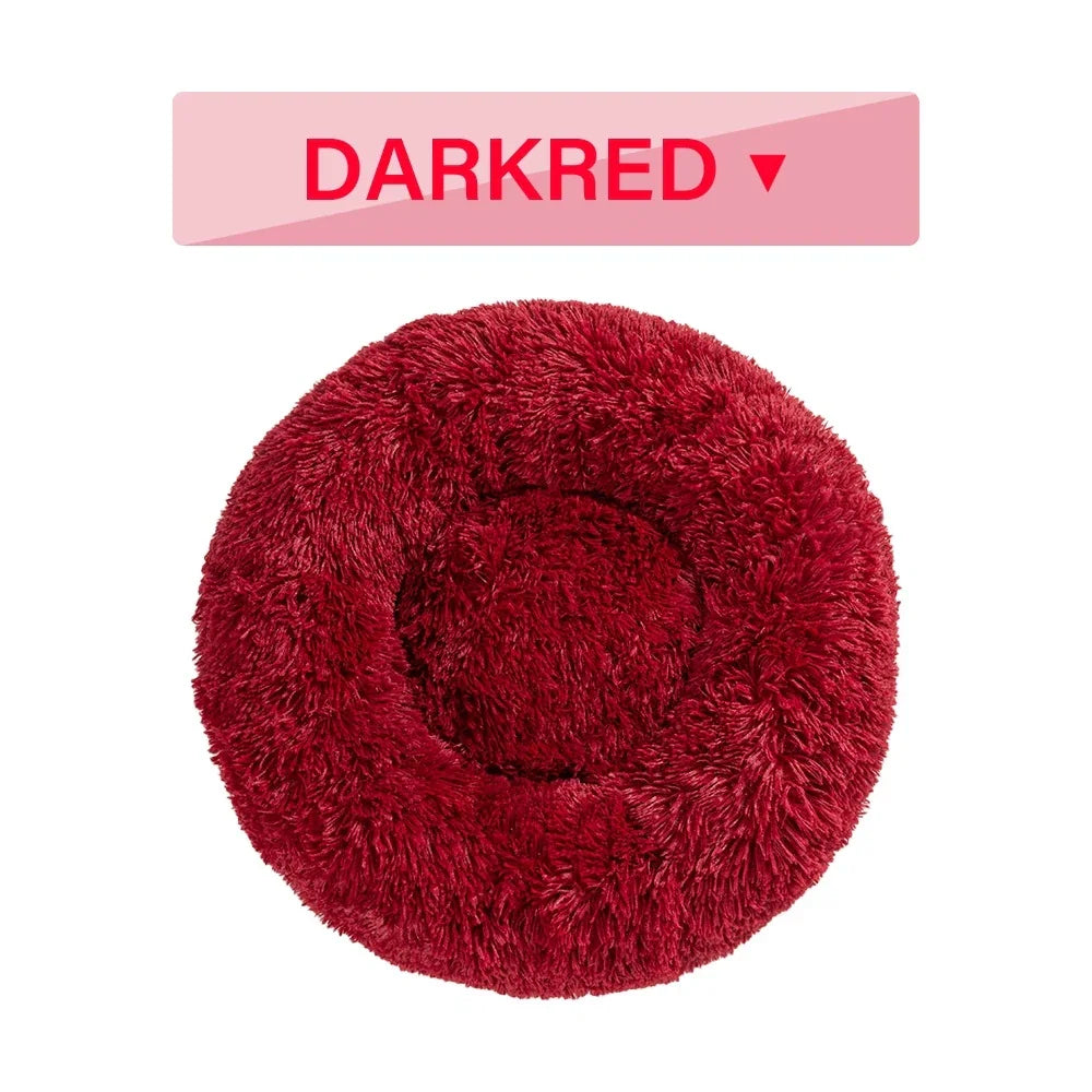 Dark red round fluffy pet bed on white background