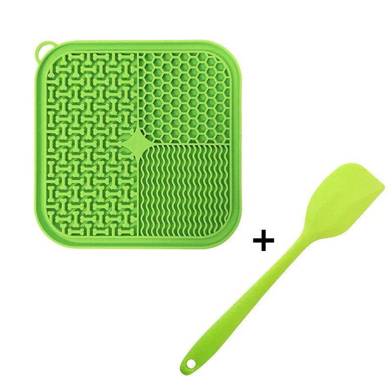 Green silicone pet licking mat with textured patterns and matching spatula