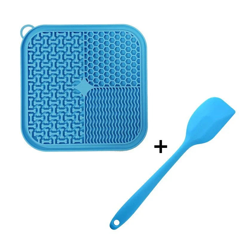 Blue silicone dog lick mat with textured surface and matching blue spatula