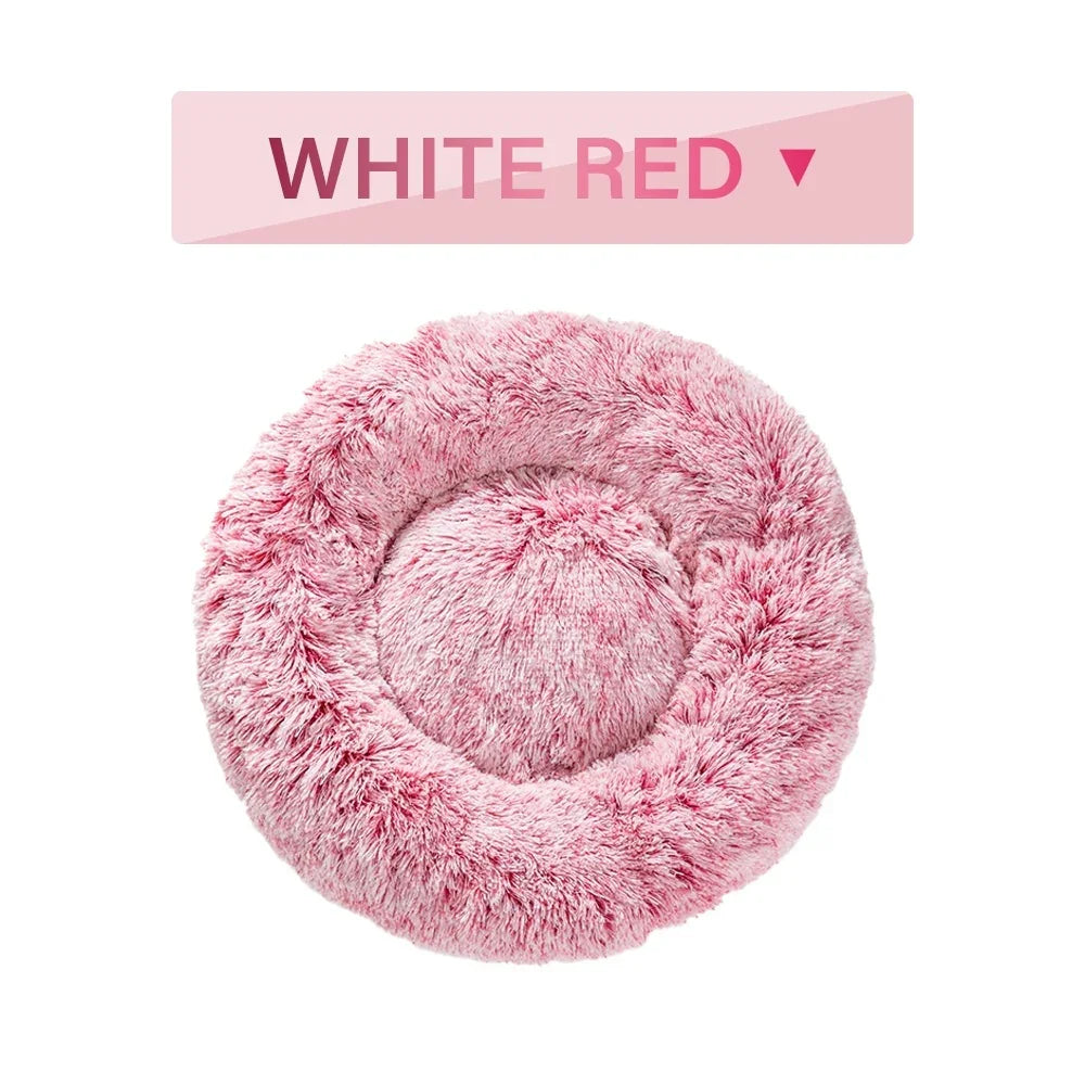 Plush round pink pet bed with fluffy texture, labeled white red, on white background.