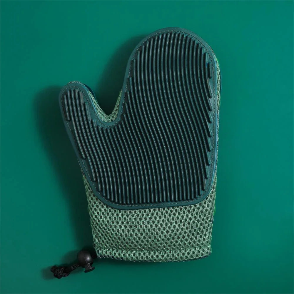 Green silicone grooming glove with textured surface on teal background