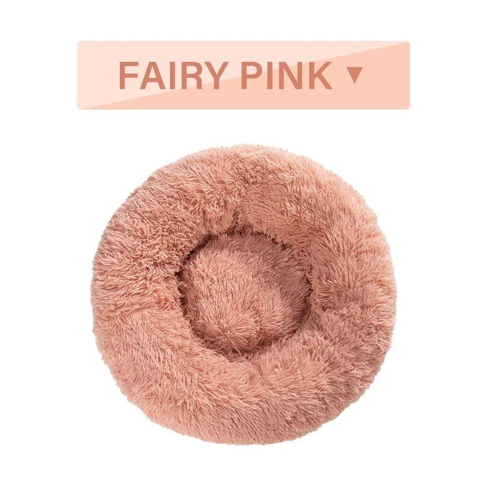 Fairy pink round fluffy pet bed with soft plush texture on white background